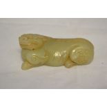 A Chinese archaistic jade carving of a crouching mythical lion with archaic 'C' scrolls on its hinds