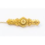 A Victorian 15ct gold bar brooch comprising a small diamond set to the centre, bead and scroll