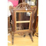 A mid 19th Century rosewood carved firescreen, raised on scroll carved feet (no panel)