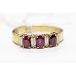 A ruby and diamond ring,  comprising three oval rubies with alternate baguette cut diamond