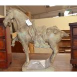 A Roman style sculpture of a horse, broken piece present, in harness