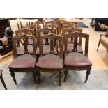 A set of twelve Victorian mahogany leather seated dining chairs, floral carving decoration on the