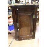 A George III oak corner cupboard, circa 1800, moulded cornice, single panel door with brass handle