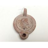 Reproduction Roman ceramic oil lamp with classical bust design to top. 75mm in diameter.