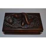 A late 19th Century carved mahogany box, the cover with a sleeping nude, enclosing an earlier carved
