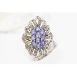 A tanzanite and 14ct white gold cluster ring, comprising a central cluster of ten oval cut