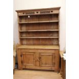 A late 19th century pine later carved dresser and sideboard, moulded cornice above carved
