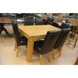 A Contemporary oak extending dining table on square supports with six leather dining chairs. (7)