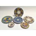 A collection of Poole Pottery including four plates, tea pot stand, and a pin dish, all marked to