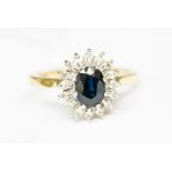 A sapphire and diamond 18ct gold cluster ring, the central oval sapphire with a diamond set