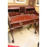 A Georgian Style mahogany desk, secret drawers, pigeon wholes and brass handle drawers, above a