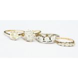 A collection of four 9ct gold rings to include a solitaire, three stone, five stone and cluster
