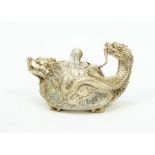 A Chinese white metal novelty teapot, in the form of a dragon, decorated with Chinese script,
