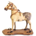 Horse: A small Victorian horse on plinth, straw filled, with saddle, height approx. 29cm.