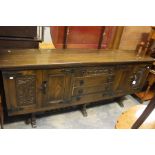 A 20th Century oak sideboard, rectangular top above four tier drawers with two panel enclosing