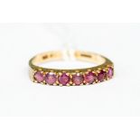A 9ct gold ruby set ladies dress ring set with seven faceted stones, size 'Q'
