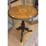 A 19th Century walnut wine table, circular table on a turned column on a tripod form with carved