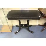 A mid Victorian aesthetic ebonised fold over card table, the top raised on four turned columns,