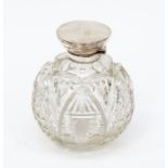 A cut glass perfume bottle, fitted with silver top, marks rubbed, missing stopper,  10cm diam, 11.