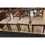 A set of four Victorian and later dining chairs, floral carve on the back rest, raised on turned