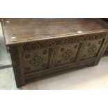 An early 18th Century carved oak blanket chest, rectangular lifting top above three panels with
