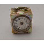 A mother of pearl clock, on four feet, with handle, approx 7.5cm high including handle (missing