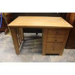 A modern oak desk, rectangular top above three graduated drawers on squared feet. 75cm H x 115cm W x