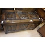 A 20th Century carved oak blanket chest, rectangular lid above three panel front, raised on bun
