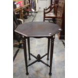 A 20th Century octagonal occasional table on turned tapered supports and stretchers on bun feet.
