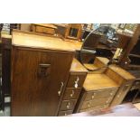 An Art Deco oak dressing table, circular mirror back on three graduated drawers with metal