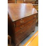 A George III oak and mahogany cross banded bureau, the fall front enclosing a fitted interior,