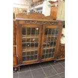 An early 20th century oak glazed bookcase, rectangular top above two panel doors with glazed