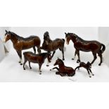 Six Beswick bay horses, four in standing position, one sitting plus a foal (6) Condition: Rear leg