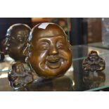 A bronze four faced Buddha's head, together with two other Buddhas