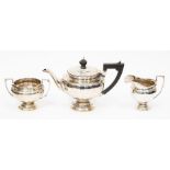 A silver tea set, comprising teapot embossed fluting to body, ebonized handle, sugar bowl and milk
