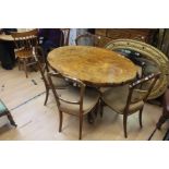 A Victorian style burr walnut floral oval shape tilt top table, octagonal column with reverse carved