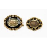 A 19ct yellow metal black enamel and pearl set oval mourning brooch, with raised scrolls to the