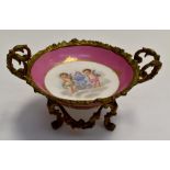 Sevres porcelain gilt metal mounted pink pedestal dish decorated with cherubs, marks to base.