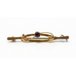 An Edwardian Art Nouveau 9ct gold bar brooch, set with a faceted amethyst