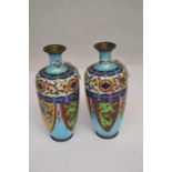 A pair of Cloisonne enamelled vases, with vibrant decoration throughout, on a blue ground, marked to