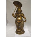 A large brass figure, possibly Ganesh, holding an umbrella, height approx. 68cm.