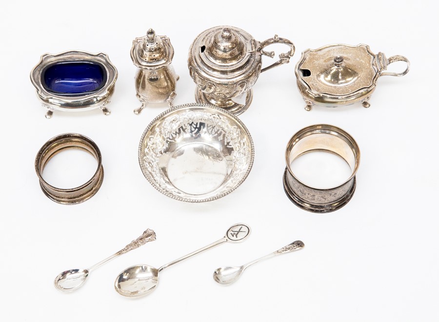 A collection of silver to include a mustard pots, salt and pepper pots, napkin rings a pin dish,