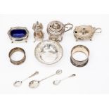A collection of silver to include a mustard pots, salt and pepper pots, napkin rings a pin dish,