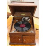 A Pelham table top gramophone, complete with records and a tin of needles