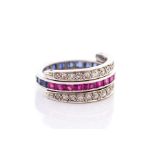 A ruby, sapphire and diamond flip ring, comprising a central row of channel set calibre cut sapphire