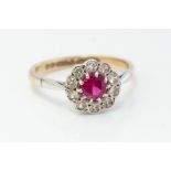 A ruby and white stone flower head 9ct gold cluster ring, comprising a round-cut ruby set to the