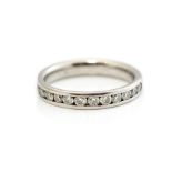 A diamond and platinum half set eternity ring, comprising fifteen round brilliant cut channel set