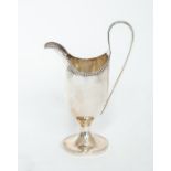 A George III plain silver helmet shaped cream jug, beaded rim on spreading circular foot with beaded