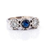 A diamond and sapphire three stone 18ct white gold ring, comprising an illusion set round cut