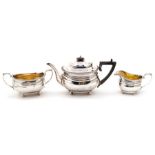 A George V silver three piece tea service comprising teapot, sugar bowl and milk jug, plain bodies